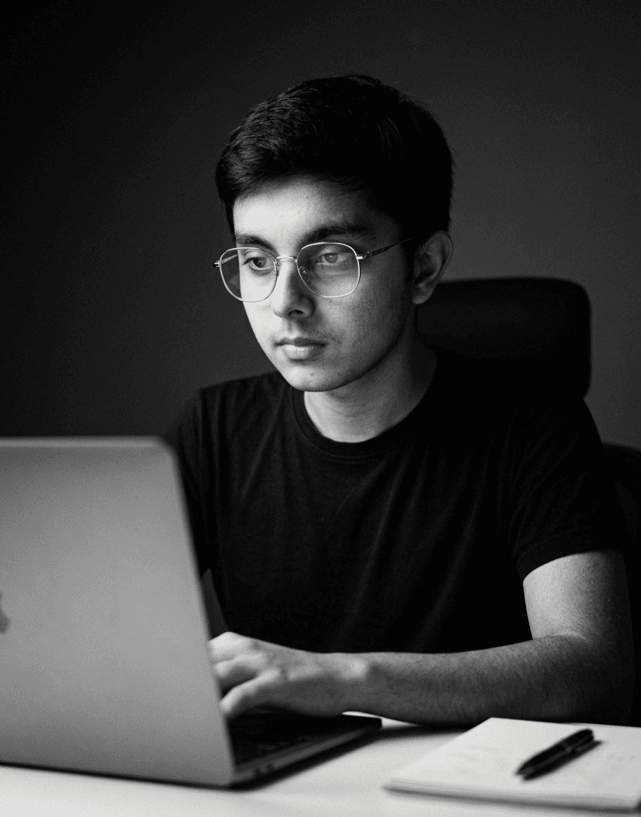 A male founder sitting on a desk and working on his laptop